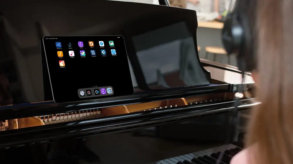C. Bechstein Connect Piano System for Learning - Image of person with headphones at piano with tablet